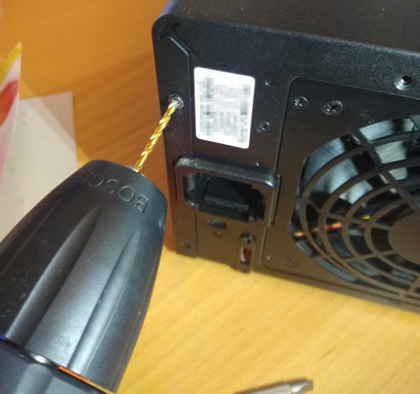 Ich bohre eine kaputte Schraube an meiner Synology-NAS auf. Links im Bild sieht man noch die Packung mit den Luftballons auf meinem Schreibtisch liegen.